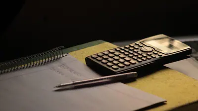 Calculatrice et carnet sur un bureau