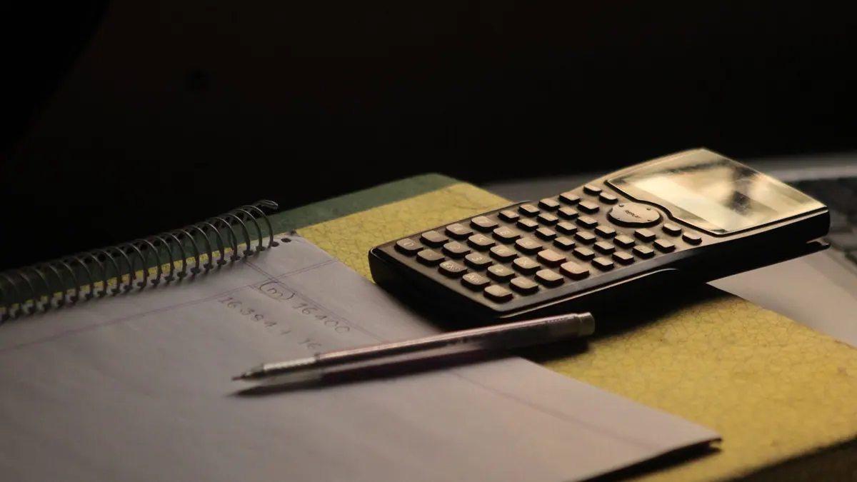 Calculatrice et carnet sur un bureau