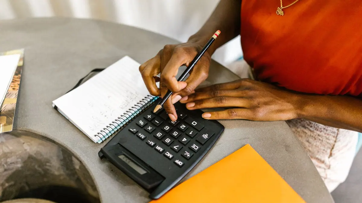 Calculatrice et prise de notes pour préparer un budget