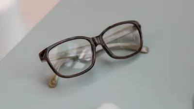 Lunettes à monture noire près d’un ordinateur fermé