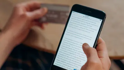 Mains tenant une carte et un téléphone pour un paiement en ligne